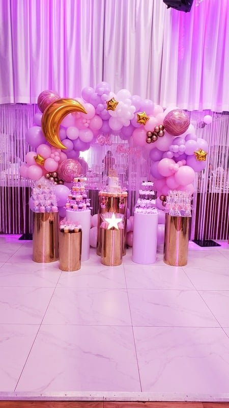 Pink and lilac organic balloon hoop with gold moon and stars over a dessert table