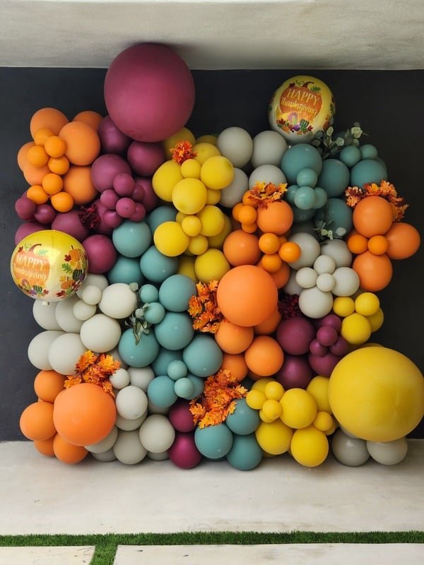Autumn-toned organic balloon wall in orange, teal, plum and yellow